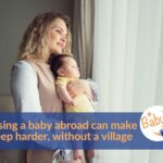 Mother holding her baby by a window on the topic of raising a baby abroad without your village
